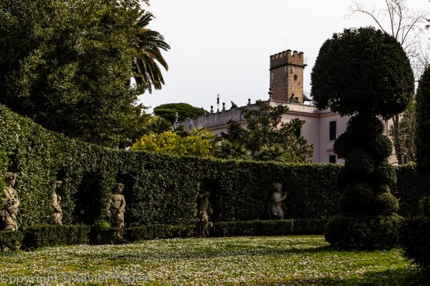 Statues surrounded by hedges, with Villa Sciarra in the background